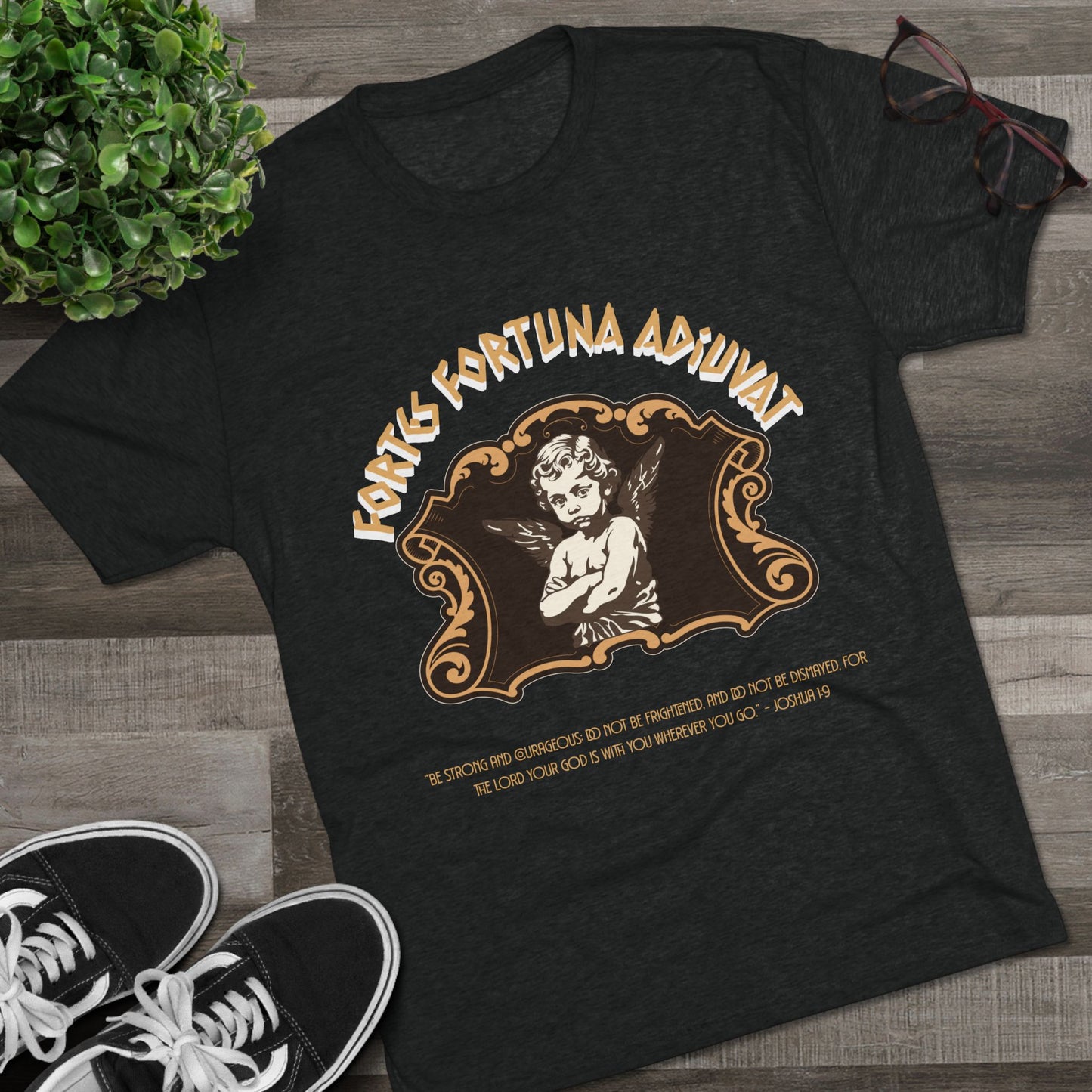 Black t-shirt with vintage-style design featuring an angel and text on a wooden surface.